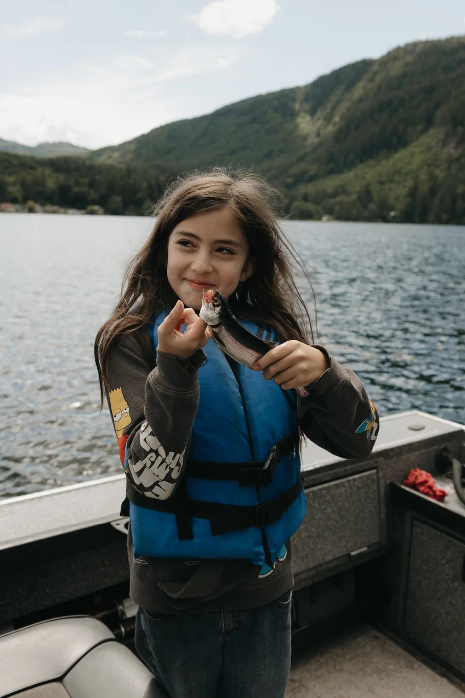 Young participant holding a fish on a lake